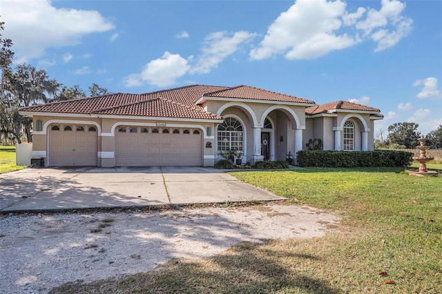 mediterranean / spanish-style house featuring a front lawn and a garage