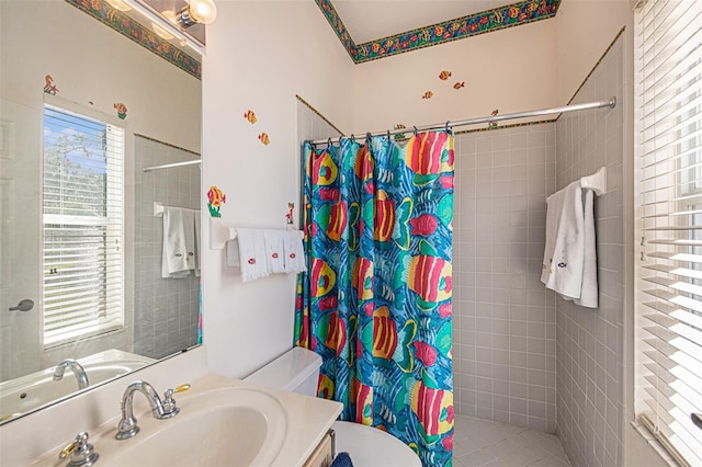 bathroom featuring a shower with shower curtain, vanity, toilet, and plenty of natural light