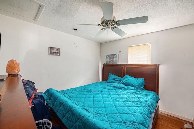 bedroom with ceiling fan, a textured ceiling, and hardwood / wood-style flooring