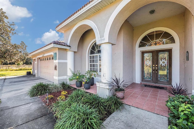 property entrance featuring a garage and french doors