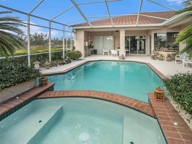 view of swimming pool featuring a bar, a lanai, ceiling fan, and a patio area