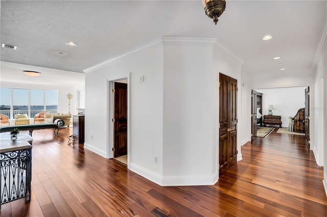 hallway featuring dark hardwood / wood-style floors and ornamental molding