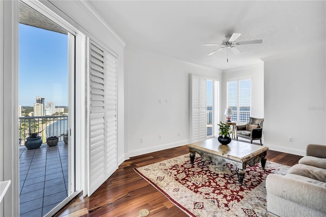 living room featuring dark hardwood / wood-style flooring, ceiling fan, and crown molding