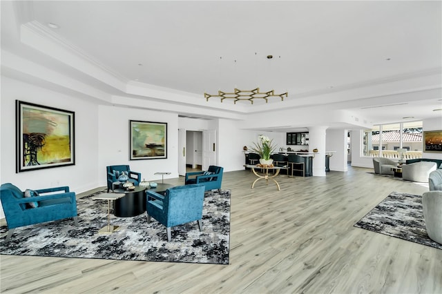 living room featuring hardwood / wood-style flooring, crown molding, and a tray ceiling