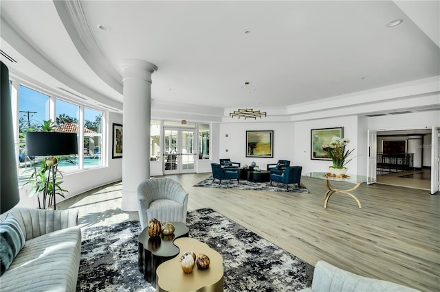 living room with wood-type flooring, french doors, and decorative columns