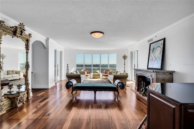 living room featuring hardwood / wood-style flooring, a textured ceiling, and crown molding