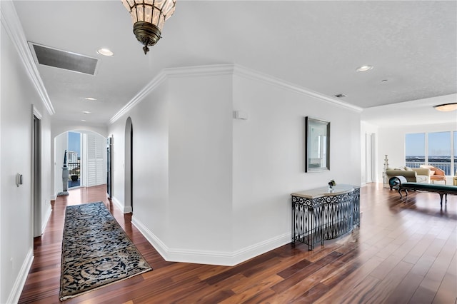 hallway featuring dark wood-type flooring and crown molding