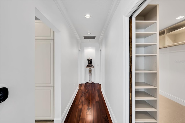 hall with dark wood-type flooring and ornamental molding