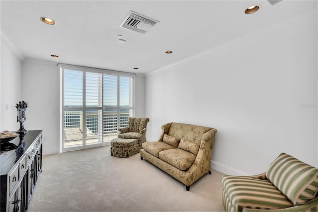 living area featuring a wealth of natural light, light colored carpet, and crown molding