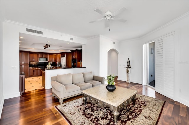 living room featuring ceiling fan, dark hardwood / wood-style floors, and crown molding