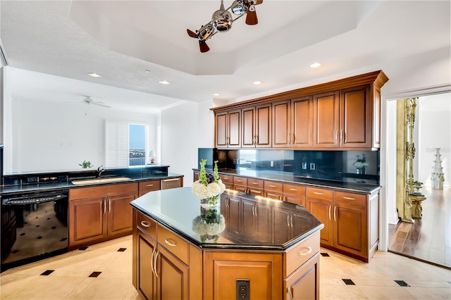 kitchen with sink, ceiling fan, a center island, dishwasher, and decorative backsplash