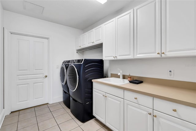 washroom with cabinets, sink, light tile patterned floors, and separate washer and dryer