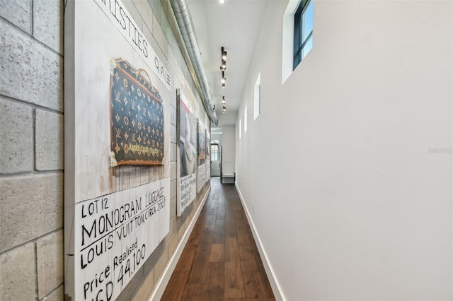 hall with dark hardwood / wood-style floors and rail lighting