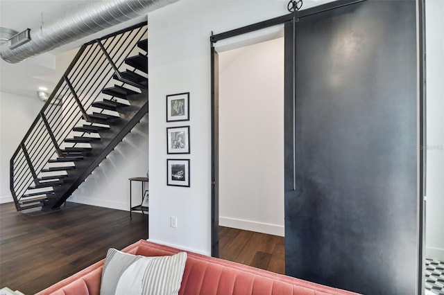 stairs with hardwood / wood-style floors and a barn door