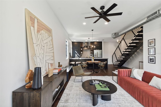 living room featuring sink, ceiling fan with notable chandelier, and dark hardwood / wood-style flooring