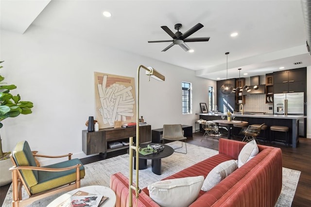 living room featuring ceiling fan and dark hardwood / wood-style flooring