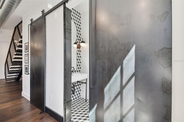 hall featuring sink, dark hardwood / wood-style flooring, and a barn door