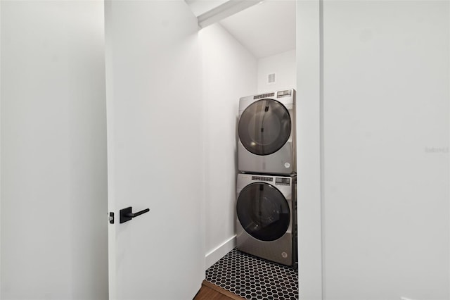 laundry area with stacked washer / dryer and hardwood / wood-style floors