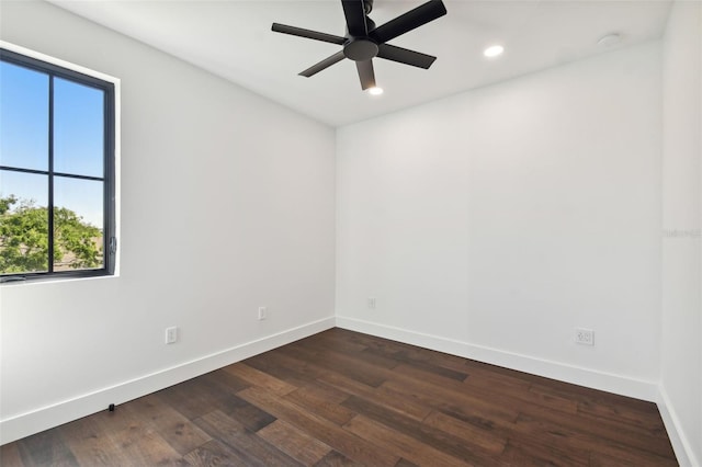 empty room with ceiling fan, a healthy amount of sunlight, and dark hardwood / wood-style flooring