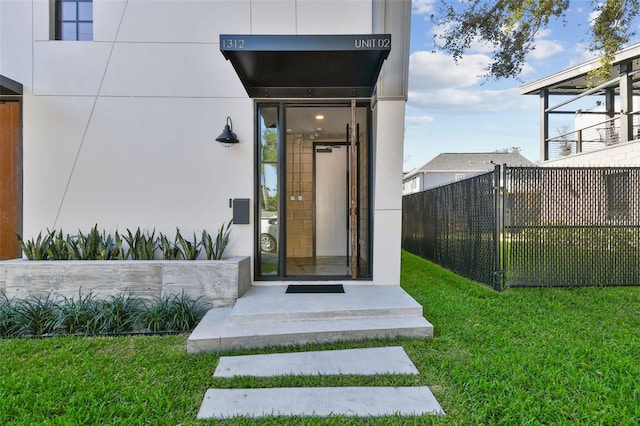 view of exterior entry featuring a yard