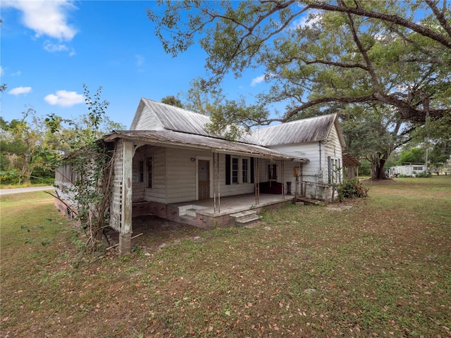 rear view of property featuring a patio and a yard