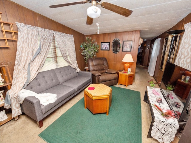 carpeted living room with wooden walls and ceiling fan