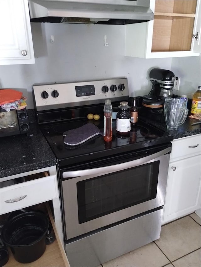 kitchen with custom range hood, light tile flooring, white cabinetry, and electric range