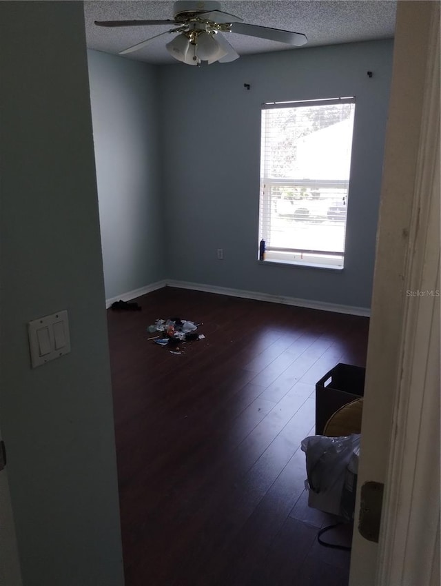 unfurnished room featuring dark hardwood / wood-style floors, a textured ceiling, and ceiling fan