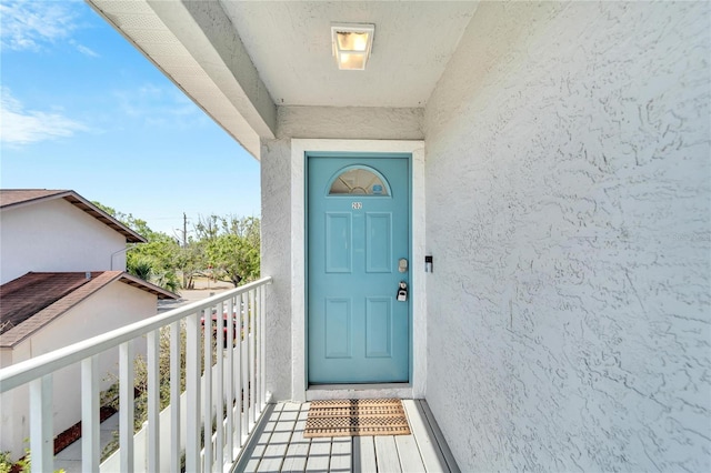 view of exterior entry featuring a balcony