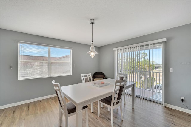 dining space with wood-type flooring