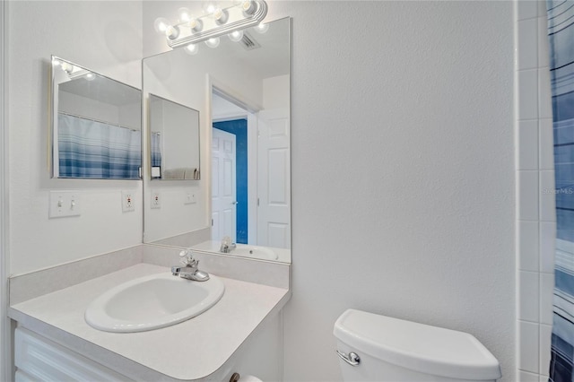 bathroom with a shower with curtain, vanity, and toilet