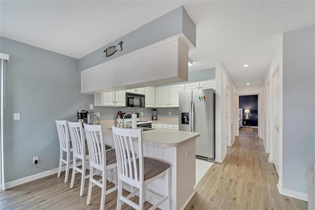 kitchen featuring stainless steel fridge with ice dispenser, white cabinets, a kitchen breakfast bar, white electric range oven, and kitchen peninsula