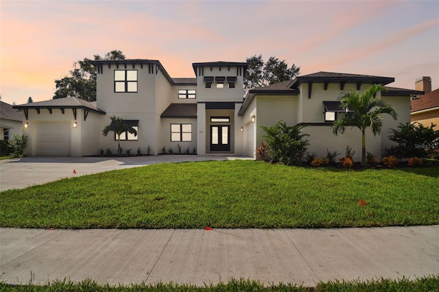 view of front of property with a garage and a yard