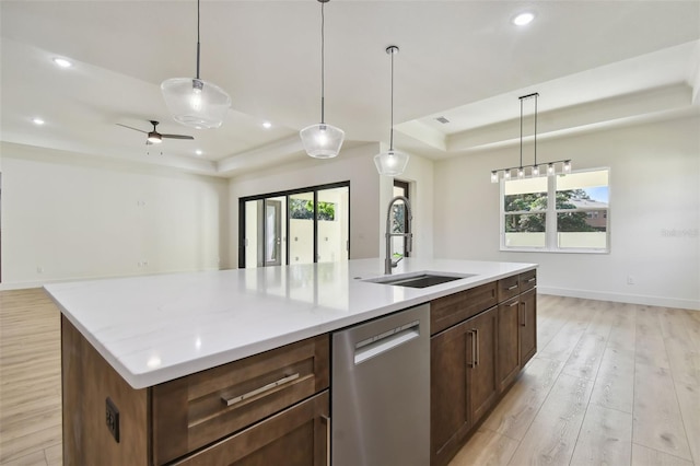 kitchen featuring dishwasher, light hardwood / wood-style flooring, a kitchen island with sink, and sink