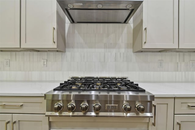 kitchen featuring extractor fan, light stone counters, stainless steel gas cooktop, and backsplash