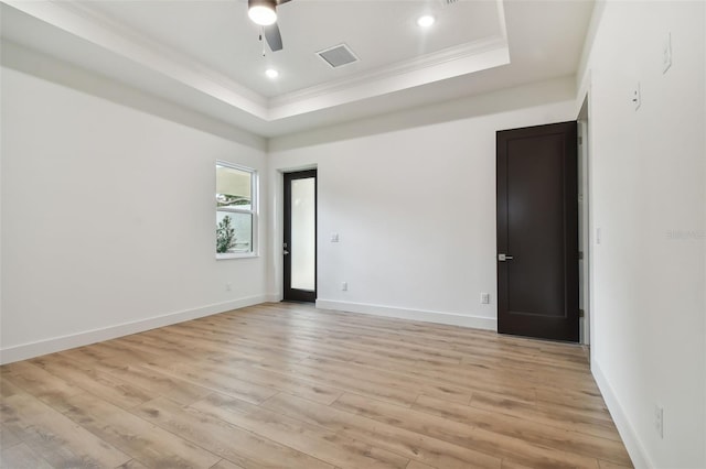 unfurnished room featuring ceiling fan, ornamental molding, light hardwood / wood-style flooring, and a tray ceiling