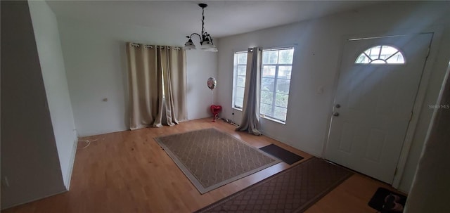 doorway featuring a chandelier and light hardwood / wood-style floors