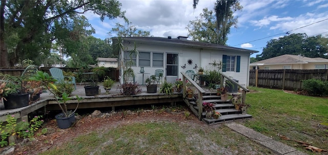 rear view of house with a yard and a deck