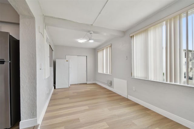 empty room with ceiling fan and light hardwood / wood-style flooring