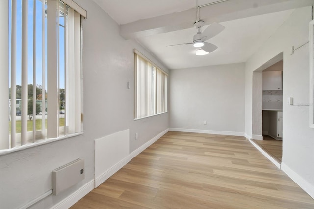 empty room with ceiling fan and light hardwood / wood-style flooring