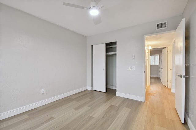 unfurnished bedroom featuring a closet, light hardwood / wood-style floors, and ceiling fan