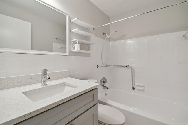 full bathroom featuring toilet, oversized vanity, tasteful backsplash, tiled shower / bath, and tile walls