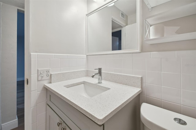 bathroom with tile walls, tasteful backsplash, and vanity