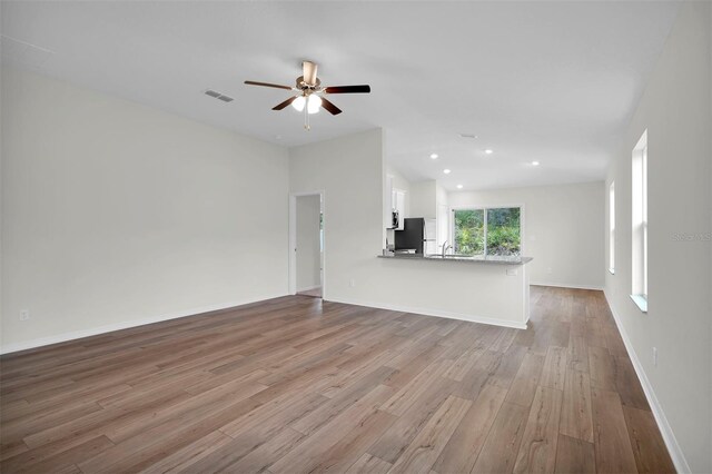 14927 SW 25th Cir, Ocala, FL 34473 - unfurnished living room with vaulted ceiling, wood finished floors, ceiling fan, baseboards, and recessed lighting