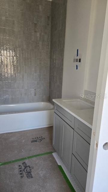 bathroom featuring vanity and tiled shower / bath