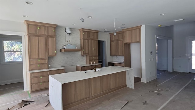 kitchen with a large island, tasteful backsplash, recessed lighting, a sink, and baseboards