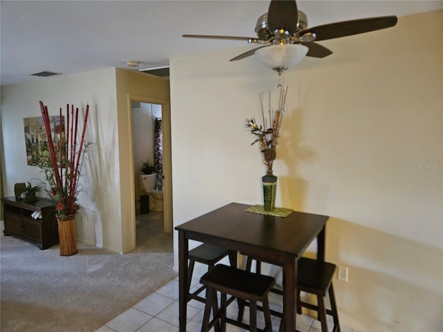 carpeted dining space featuring ceiling fan