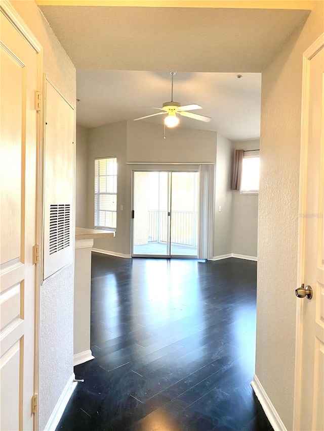 unfurnished room featuring dark wood-type flooring and ceiling fan