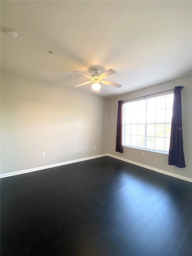 spare room featuring dark hardwood / wood-style floors and ceiling fan