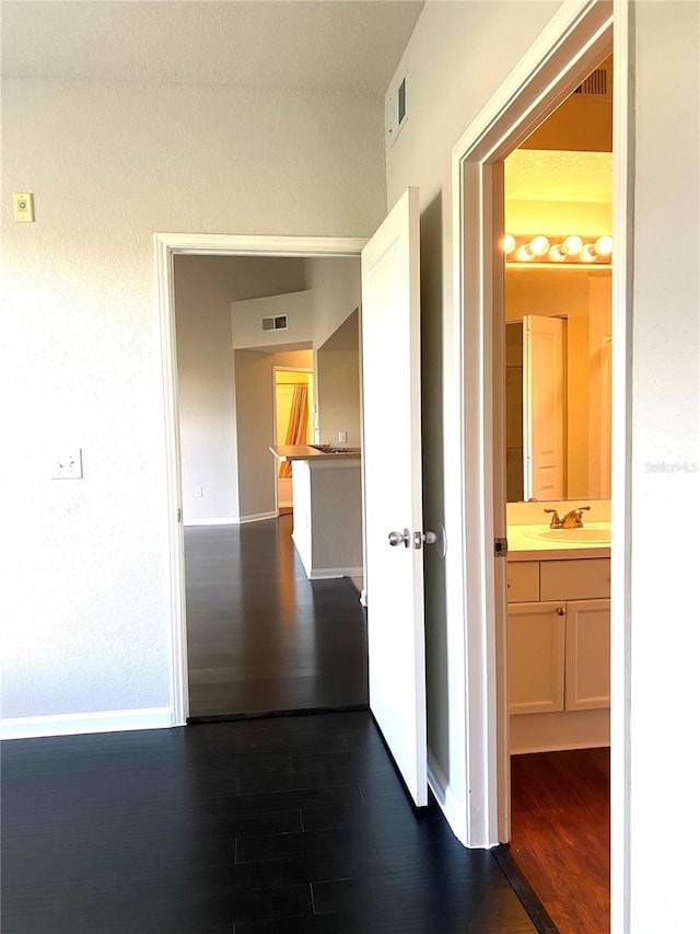 corridor featuring dark hardwood / wood-style flooring and sink